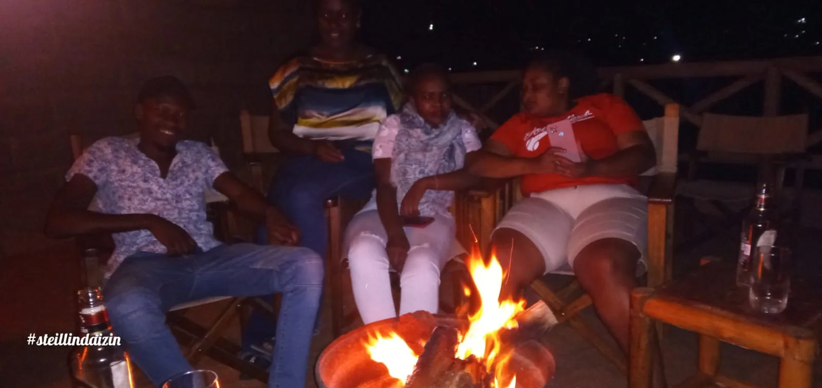 A group of friends sitting around a bonfire at night