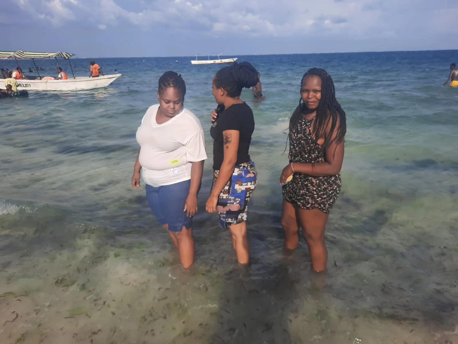 Three travellers wading in the sea at Nyali Beach, Mombasa